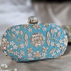 Hand embroidered oval clutch.